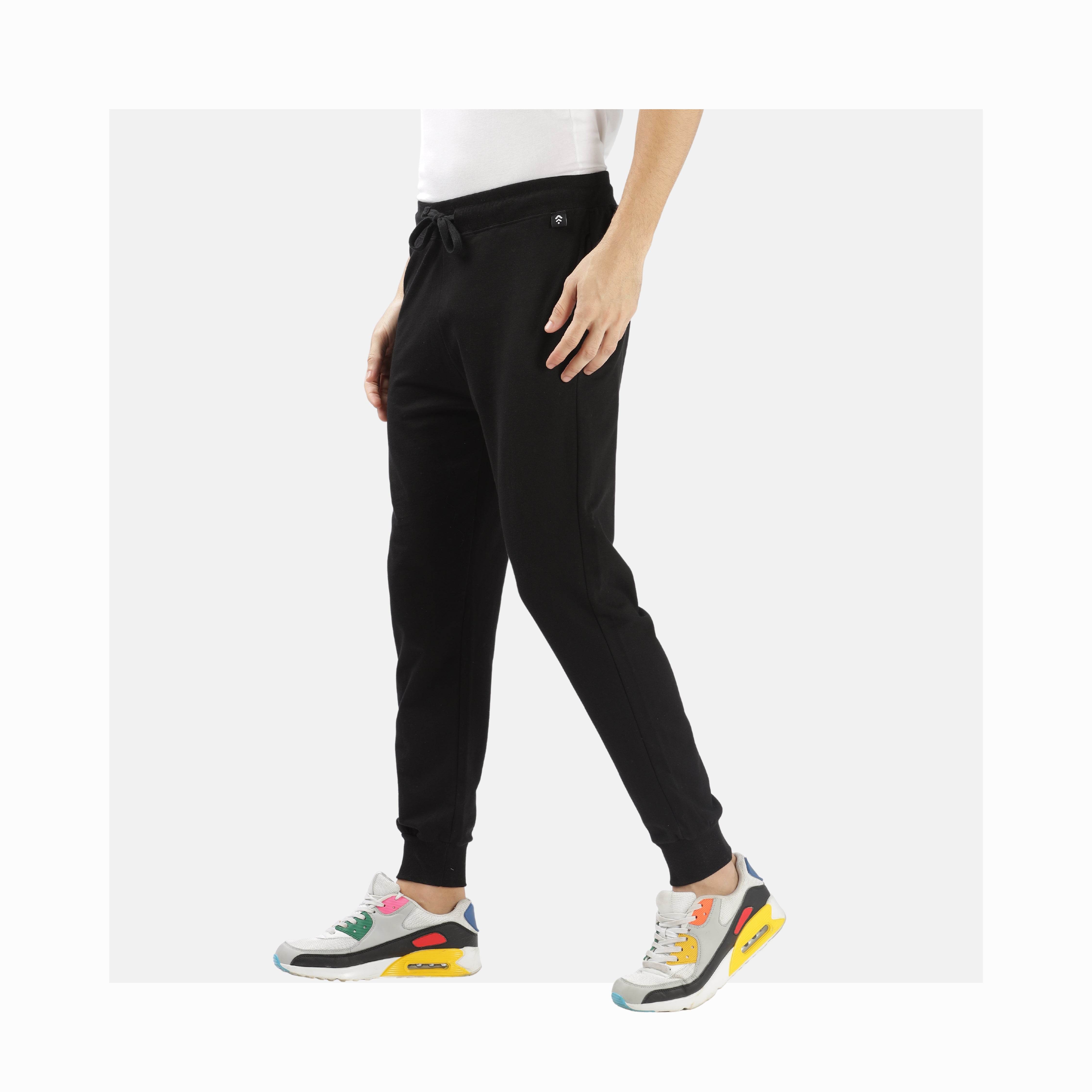Unisex French terry joggers in black with a relaxed fit paired with colorful sneakers