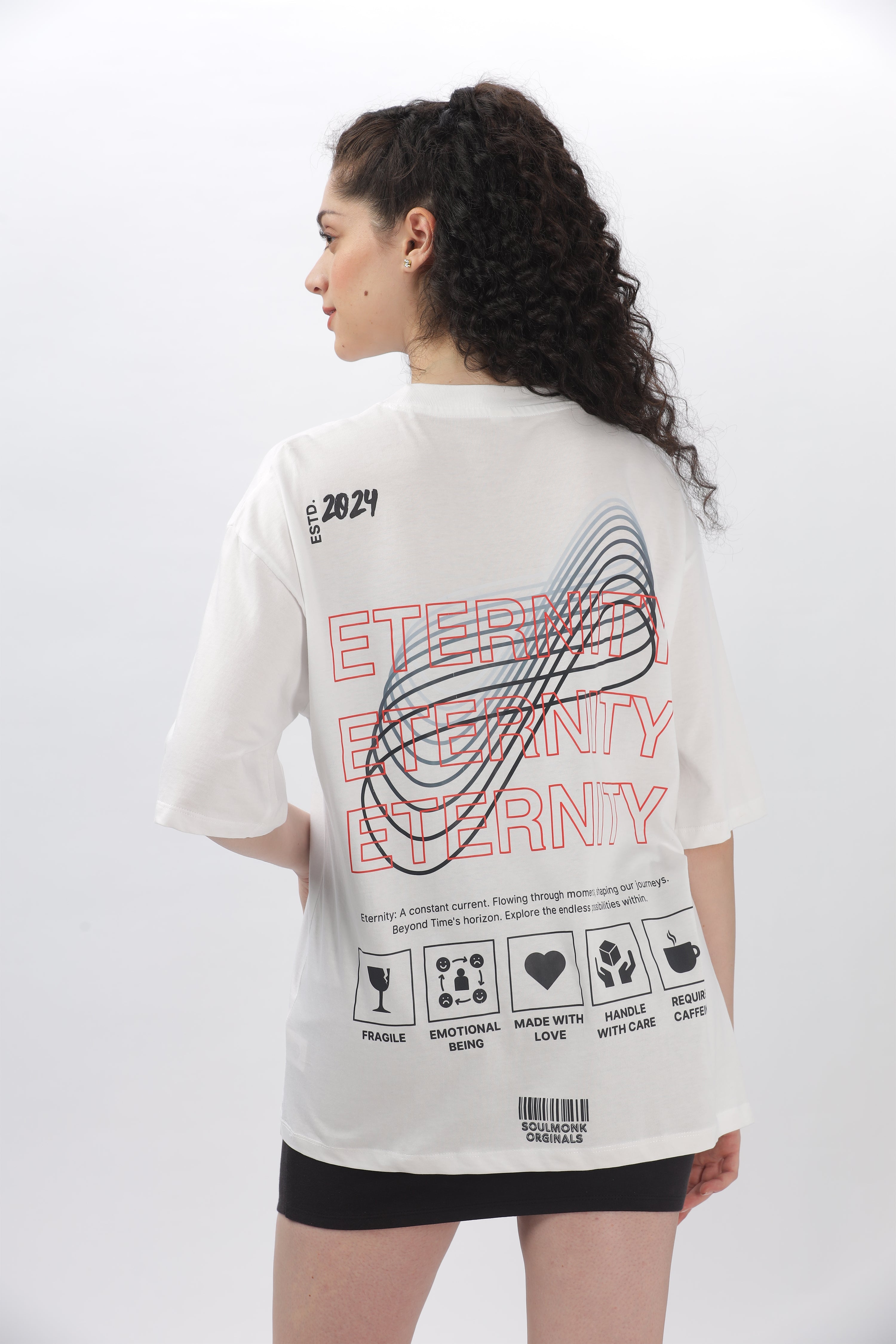 Woman wearing Eternity Collection oversized t-shirts for women in white with bold graphic print on back