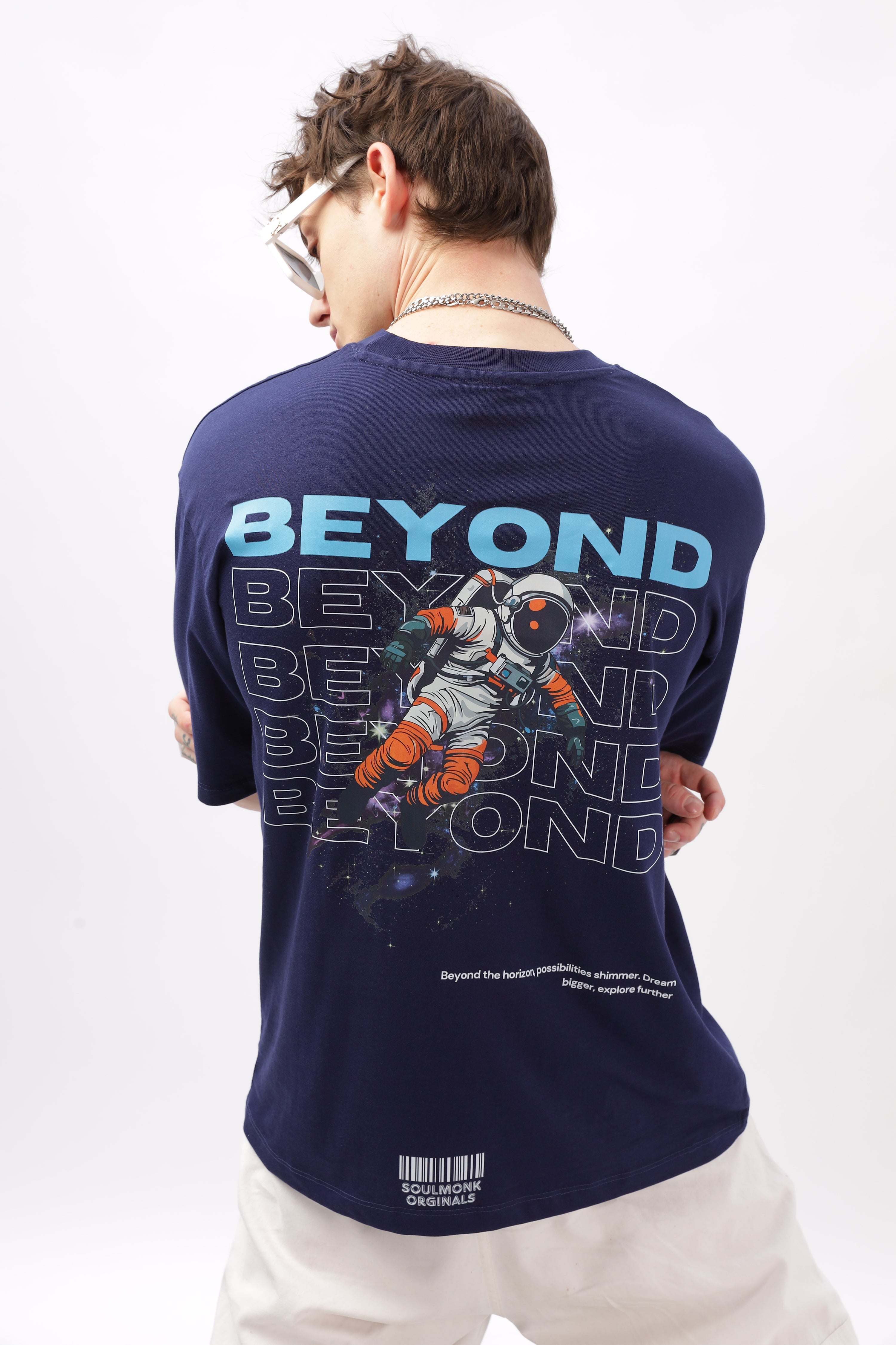 Man wearing navy printed oversized t shirt for men with astronaut and beyond text design