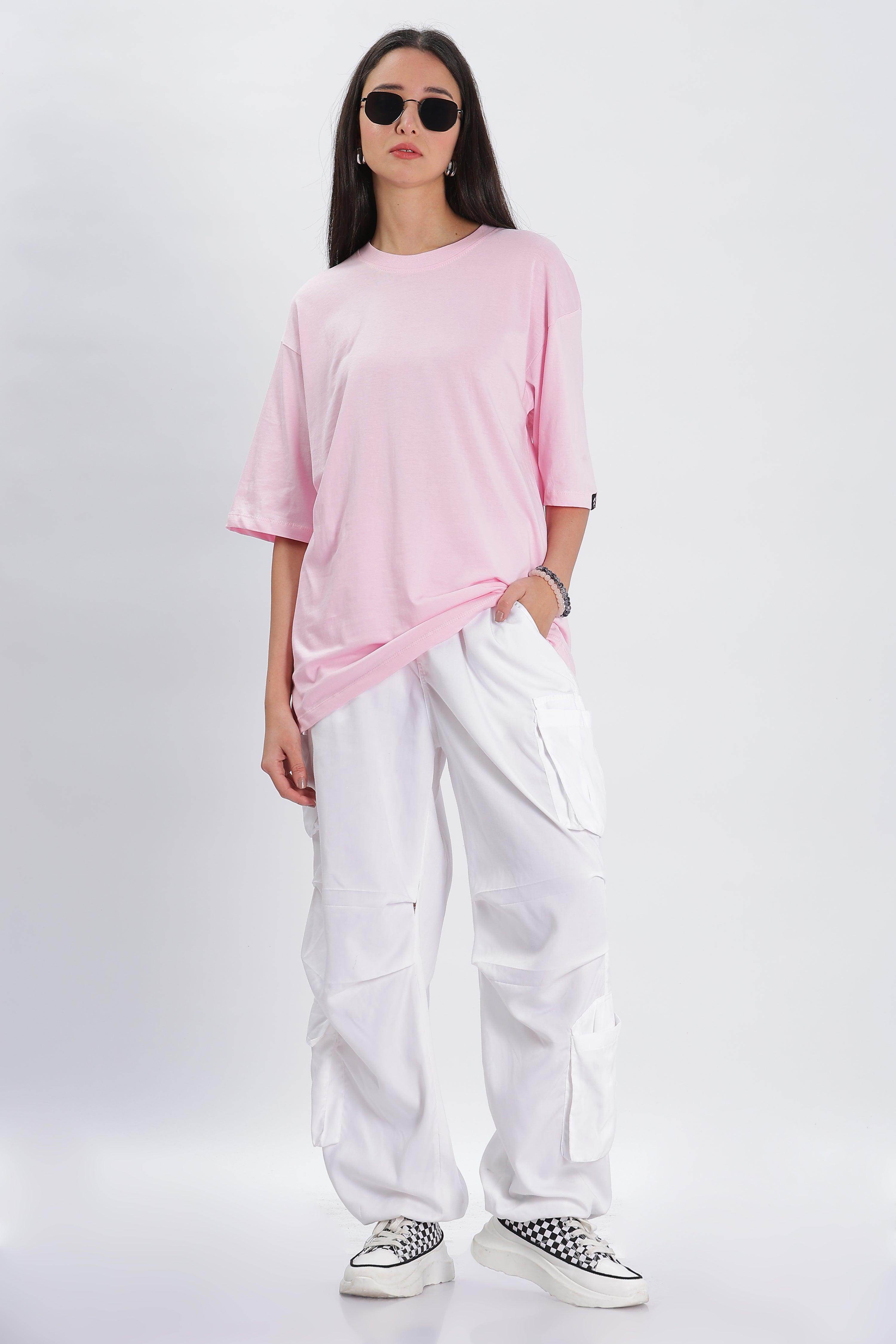 Model wearing a pink oversized solid t-shirt paired with white cargo pants and sneakers