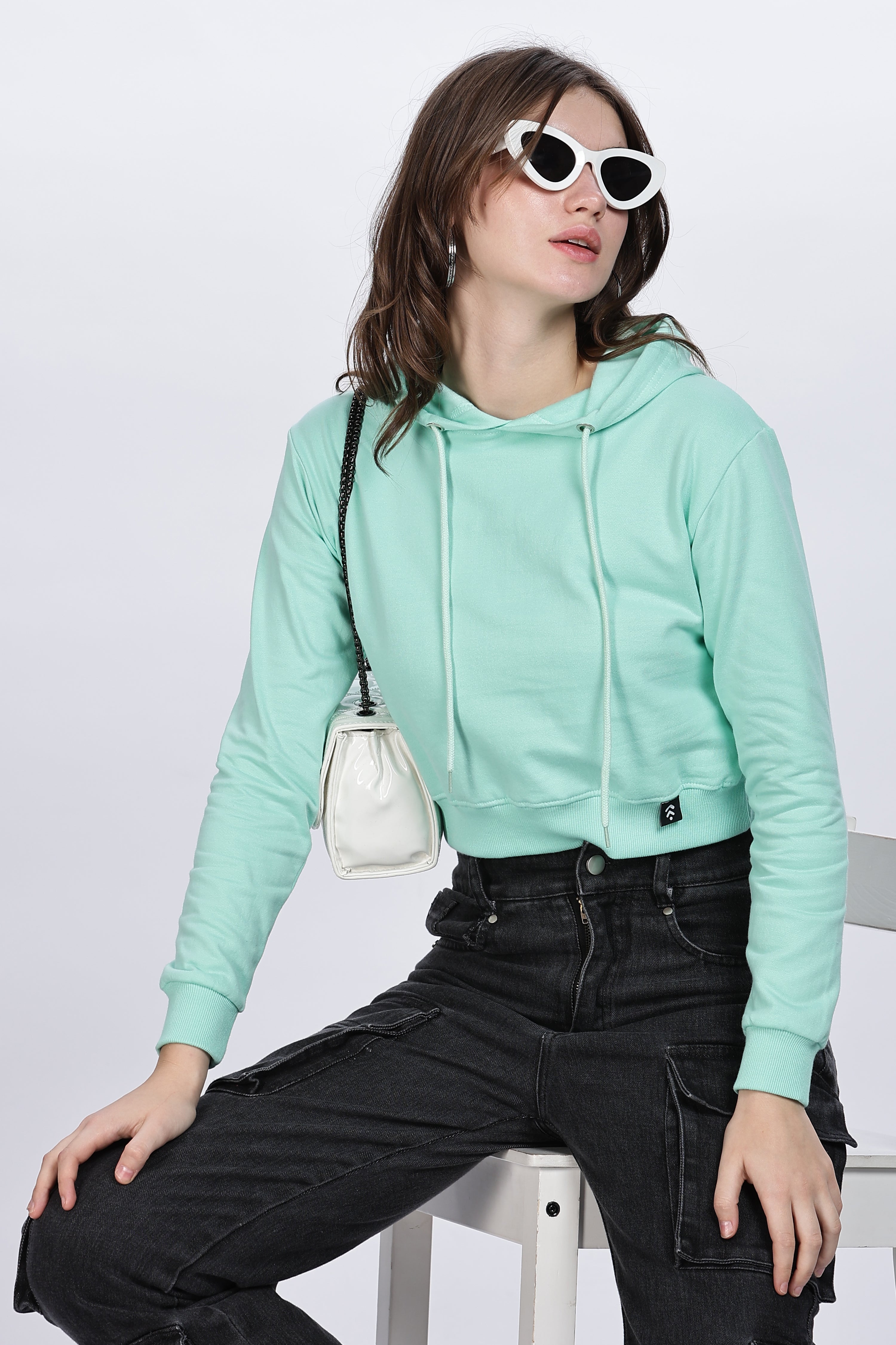 Woman wearing mint green crop hoodie and black pants showcasing 70 percent off lon oungewear sale styles