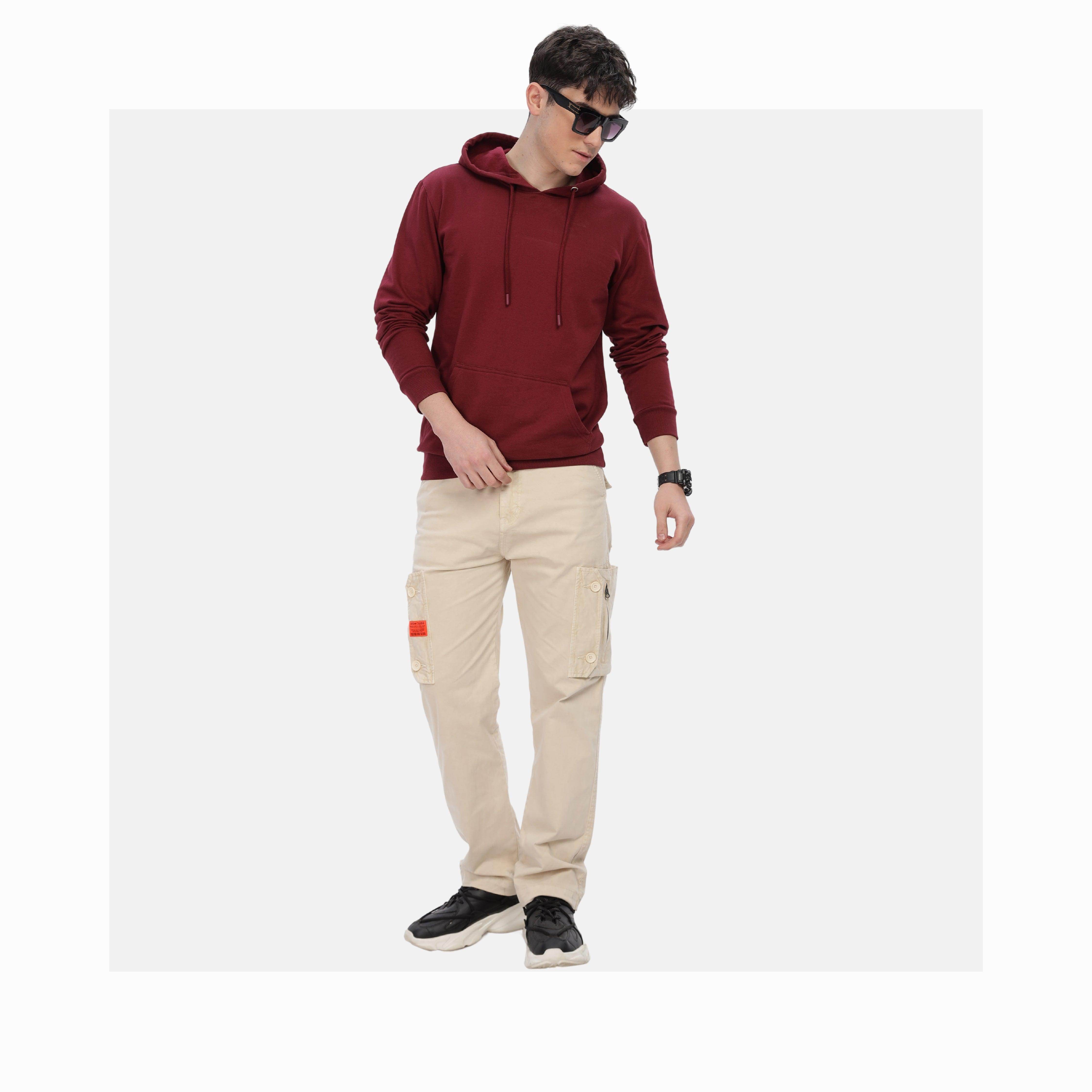 Man wearing a maroon red unisex cotton hoodie paired with beige cargo pants and black sneakers