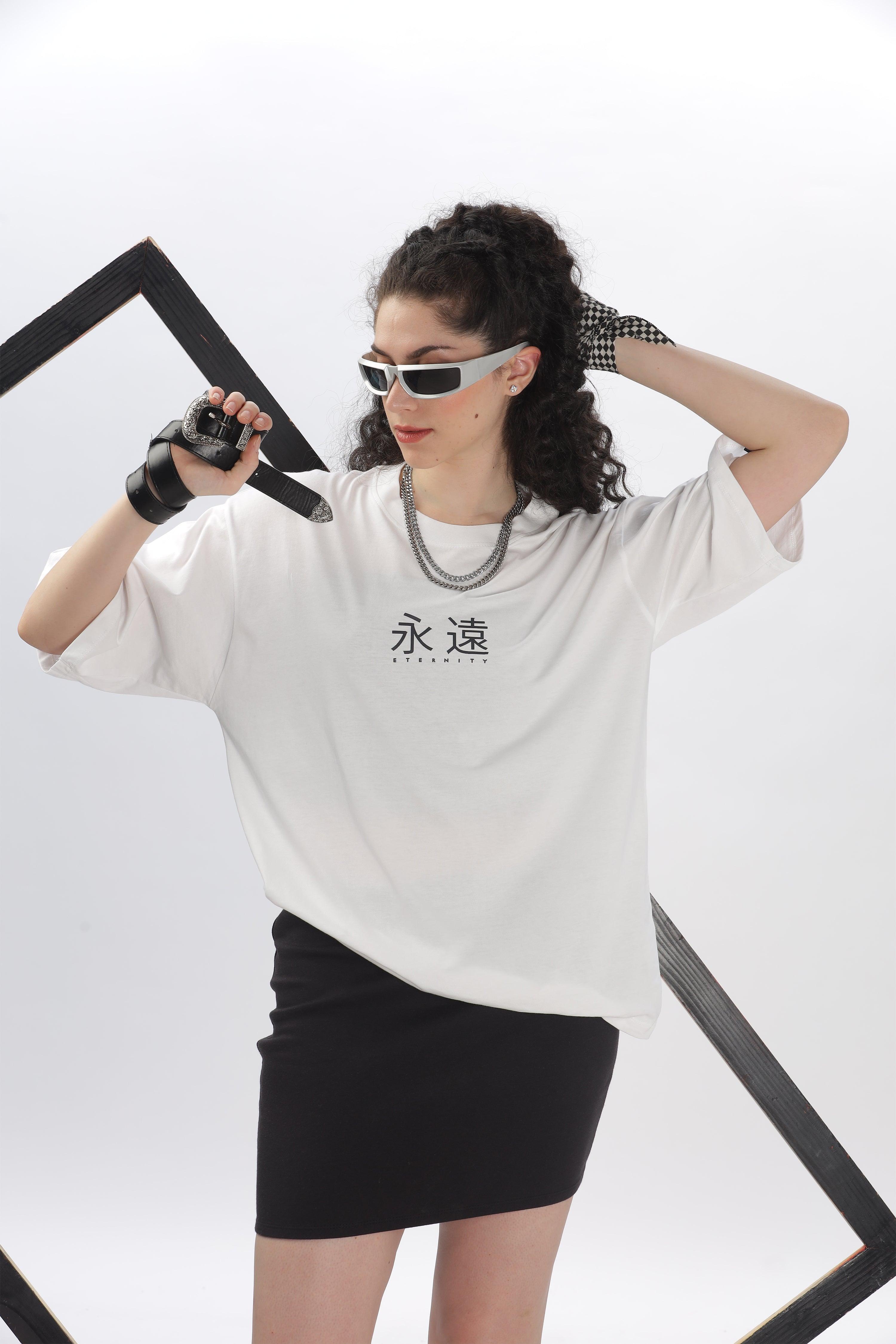 Woman wearing a white oversized t-shirt for women with black text paired with a black skirt and stylish accessories
