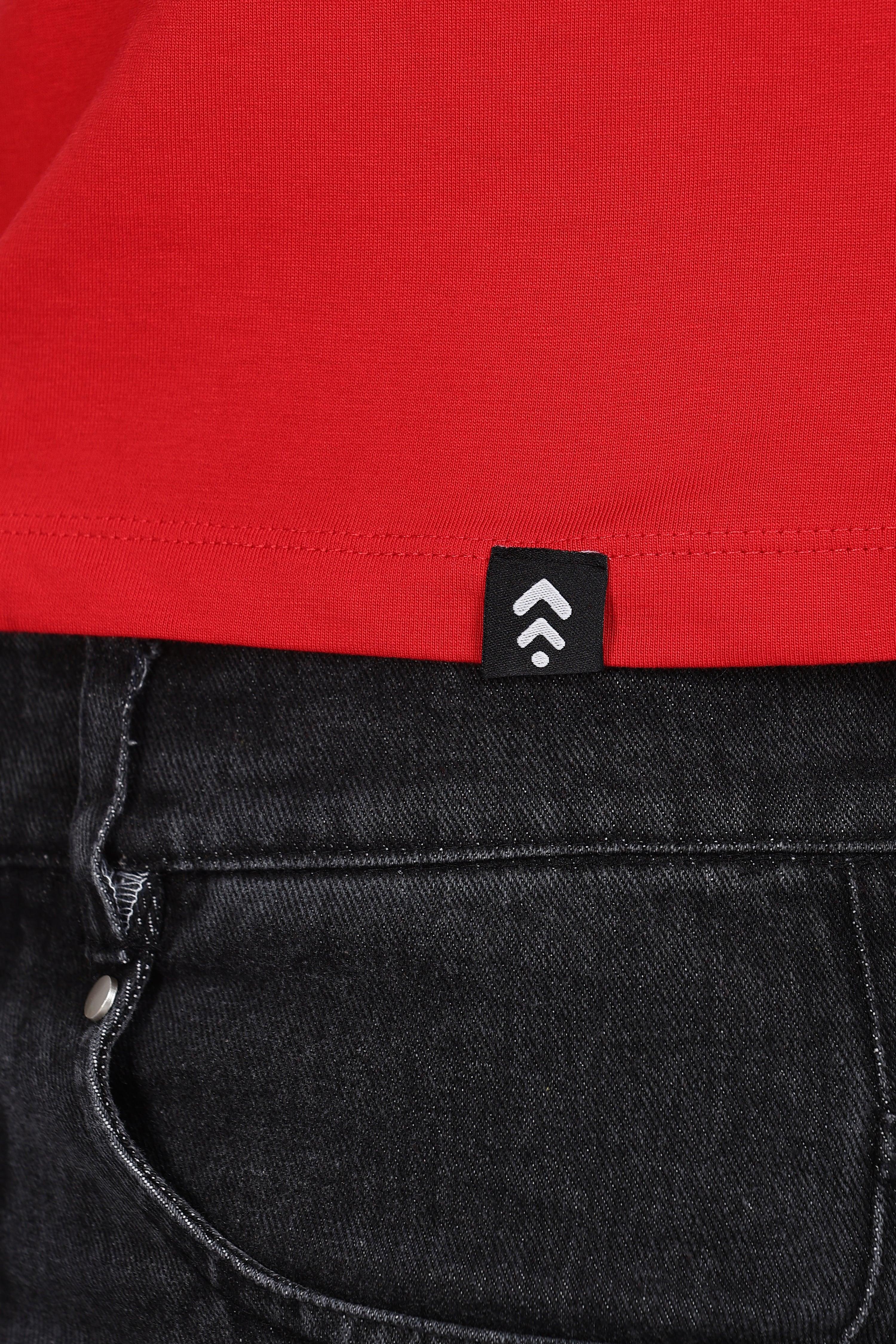 Close-up of Soulmonk red solid crop top hem with logo tag paired with black denim jeans
