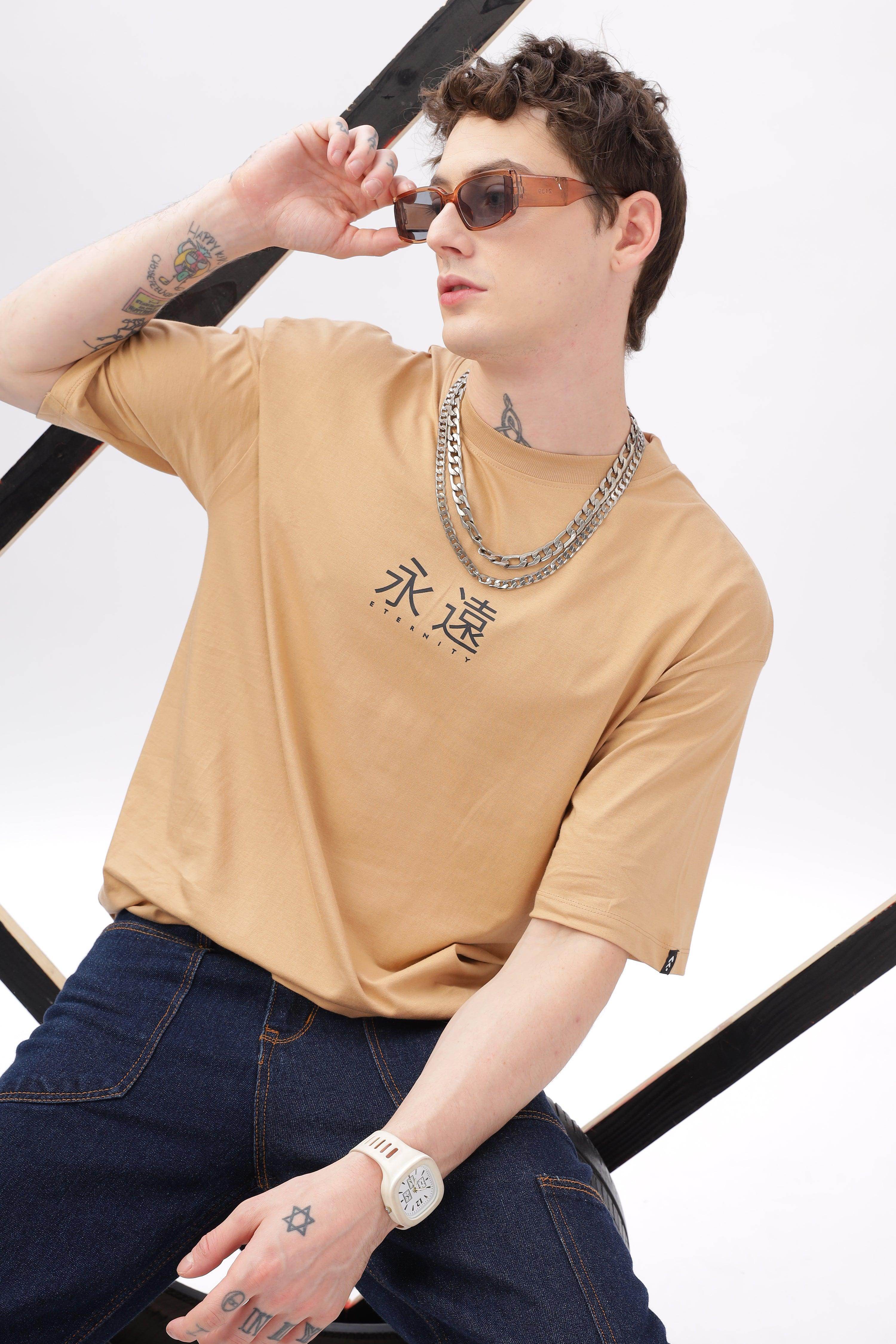 Soulmonk male model wearing taupe oversized t-shirt with black graphic and silver chain necklace