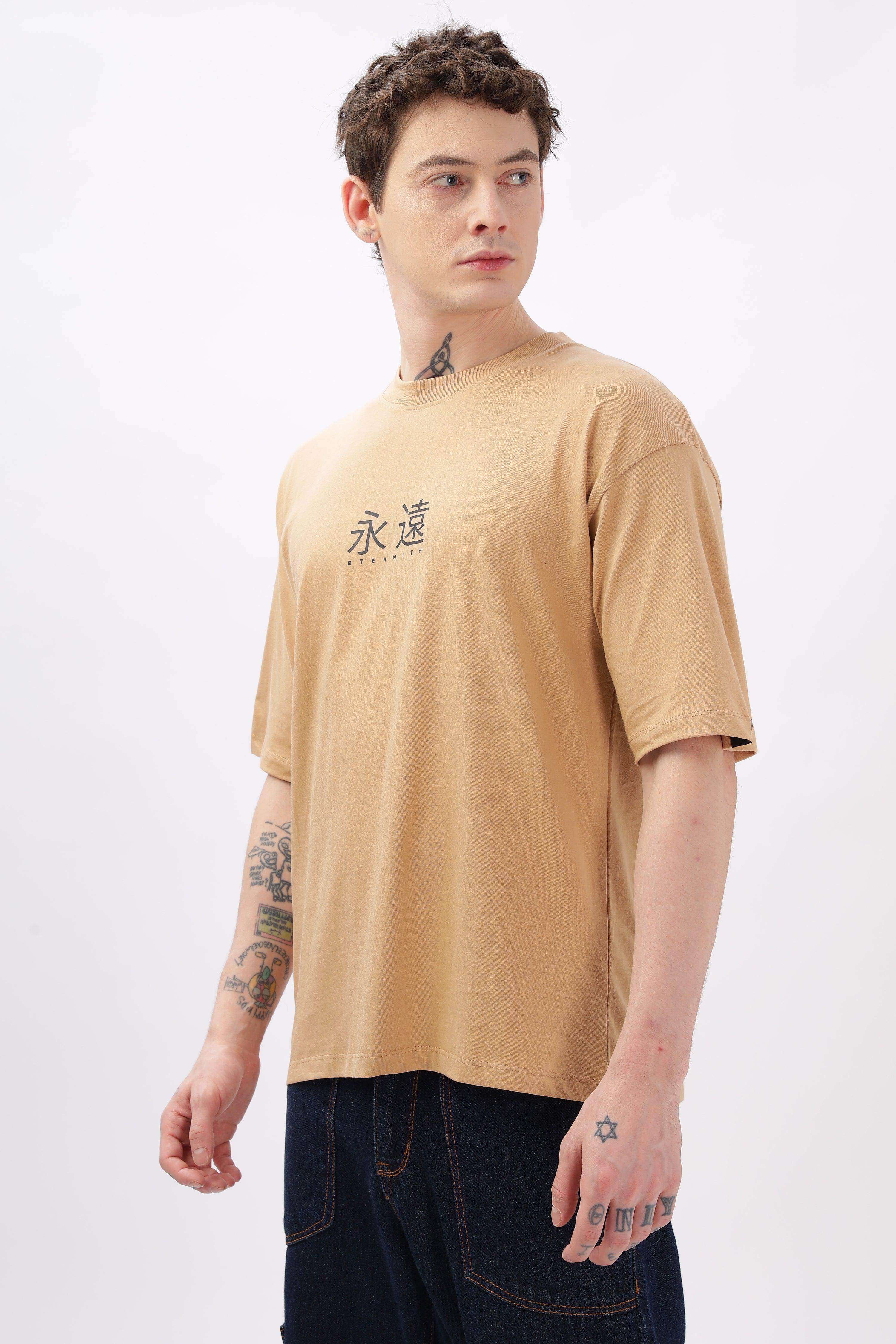 Male model wearing Soulmonk taupe oversized t-shirt with black text and dark jeans