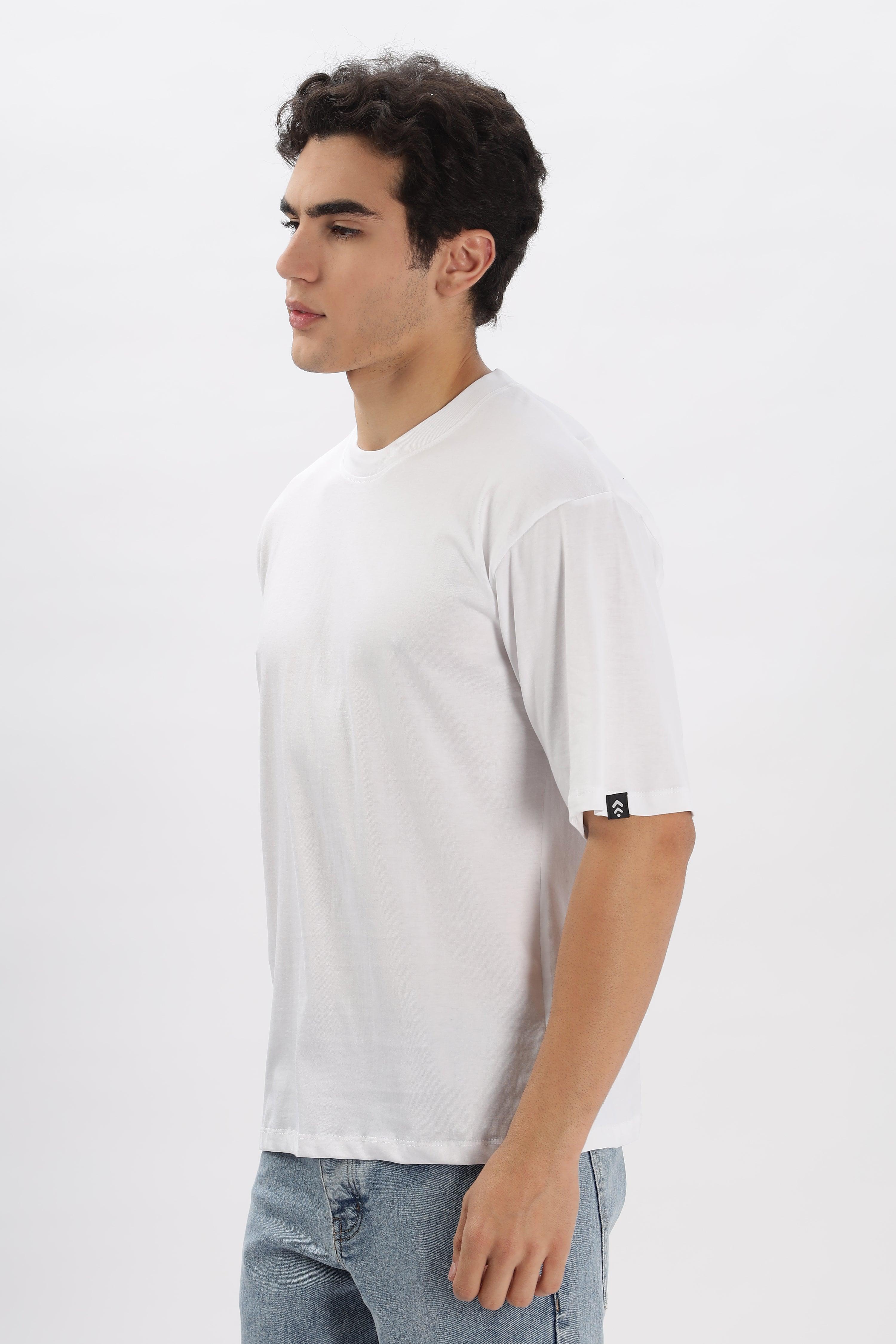 Male model wearing a white oversized t-shirt for men by Soulmonk paired with light blue jeans
