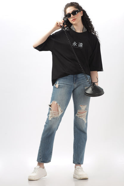 Soulmonk black oversized t-shirt for women paired with ripped jeans and white sneakers