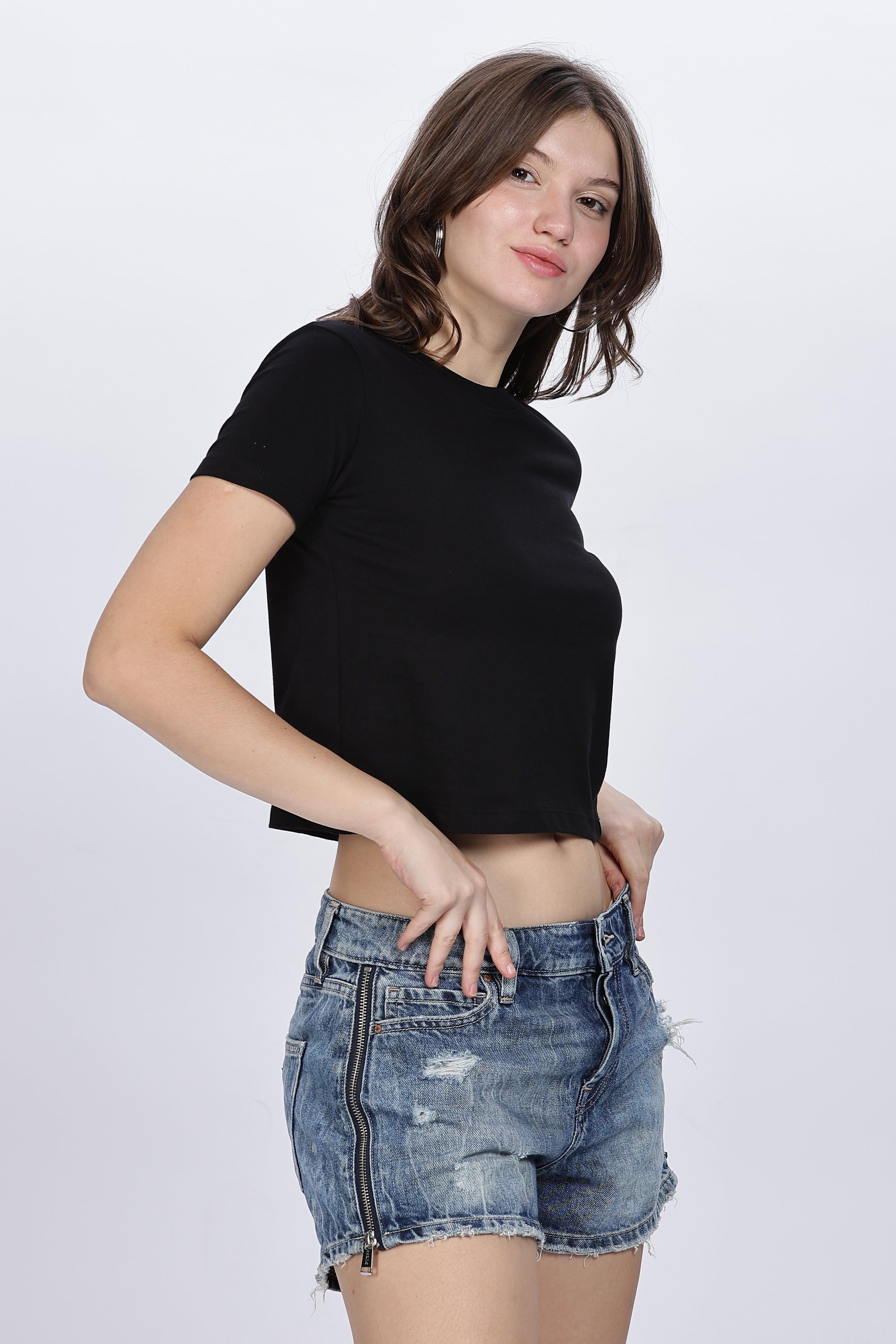 Female model wearing Soulmonk black solid crop top paired with distressed denim shorts