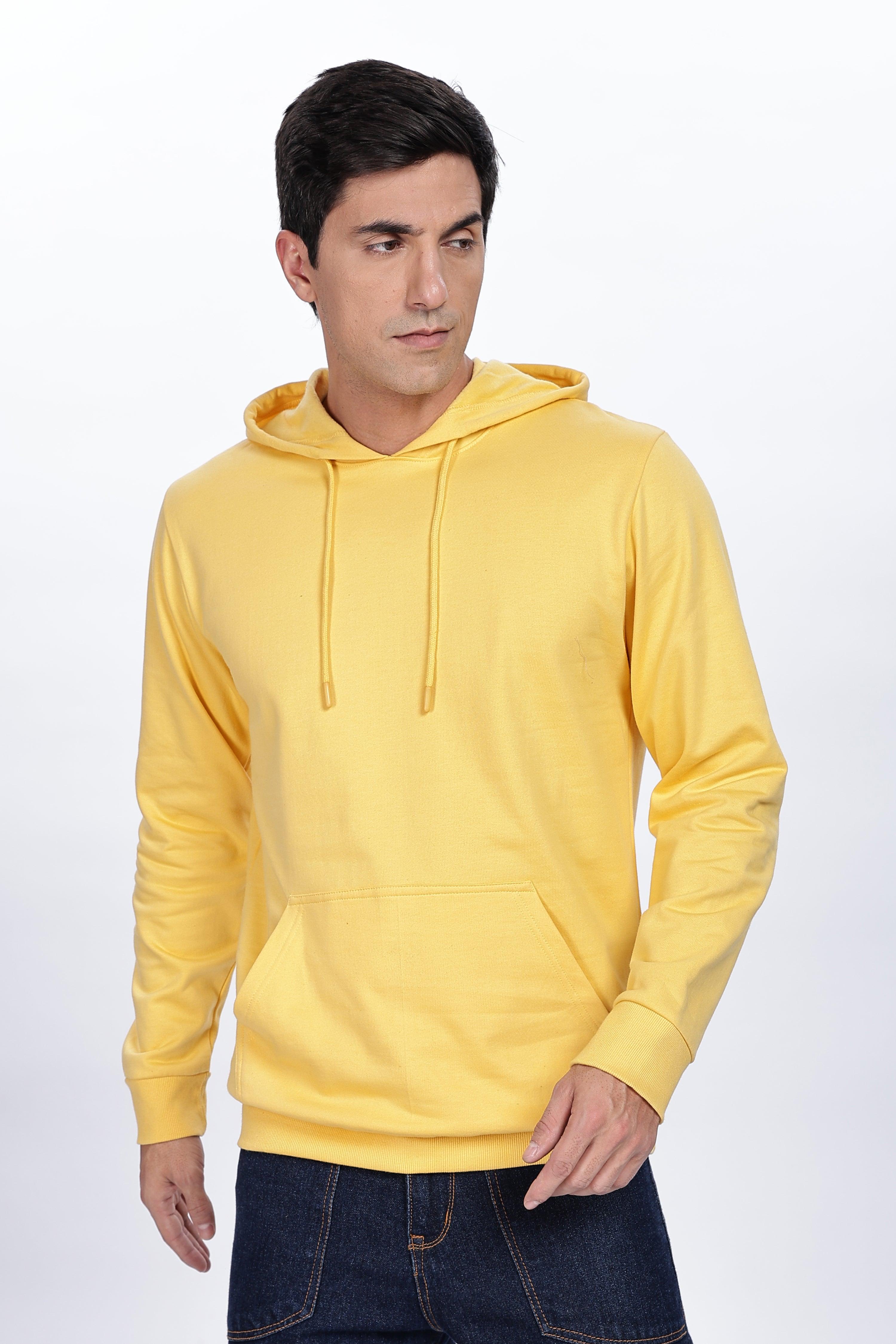 Male model wearing a Soulmonk golden yellow hoodie with front pocket and drawstring hood
