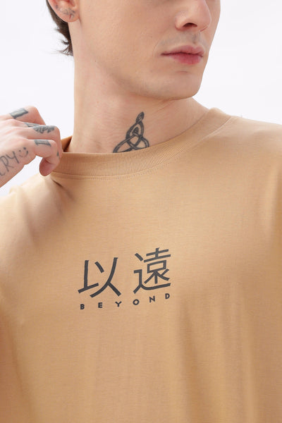Male model wearing Soulmonk oversized taupe t-shirt with black japanese characters and Beyond text