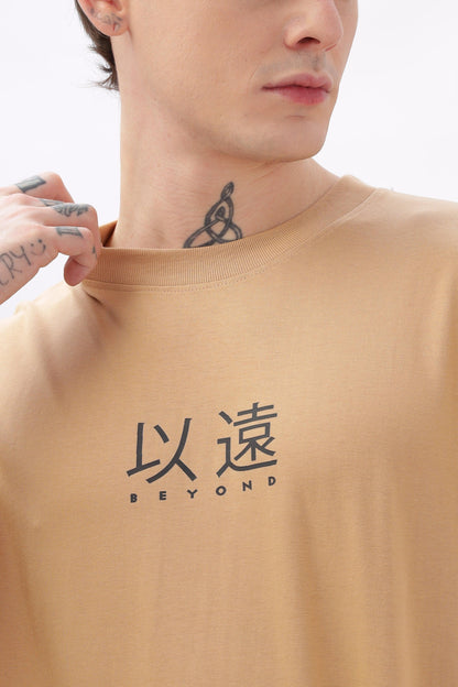 Male model wearing Soulmonk oversized taupe t-shirt with black japanese characters and Beyond text