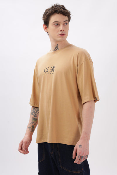 Male model wearing oversized taupe t-shirt by Soulmonk with printed design on front