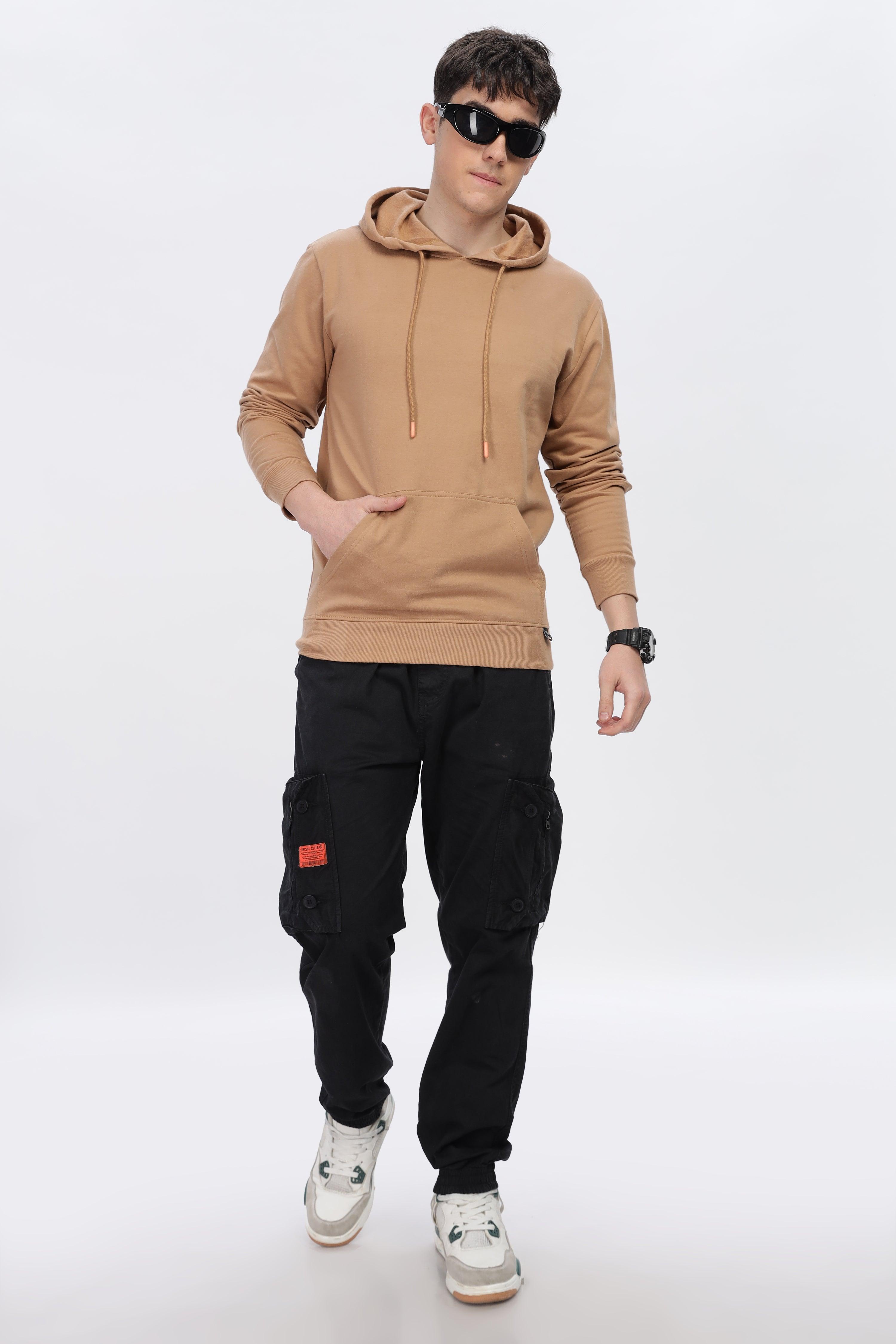 Male model wearing Soulmonk caramel brown hoodie with black cargo pants and white sneakers