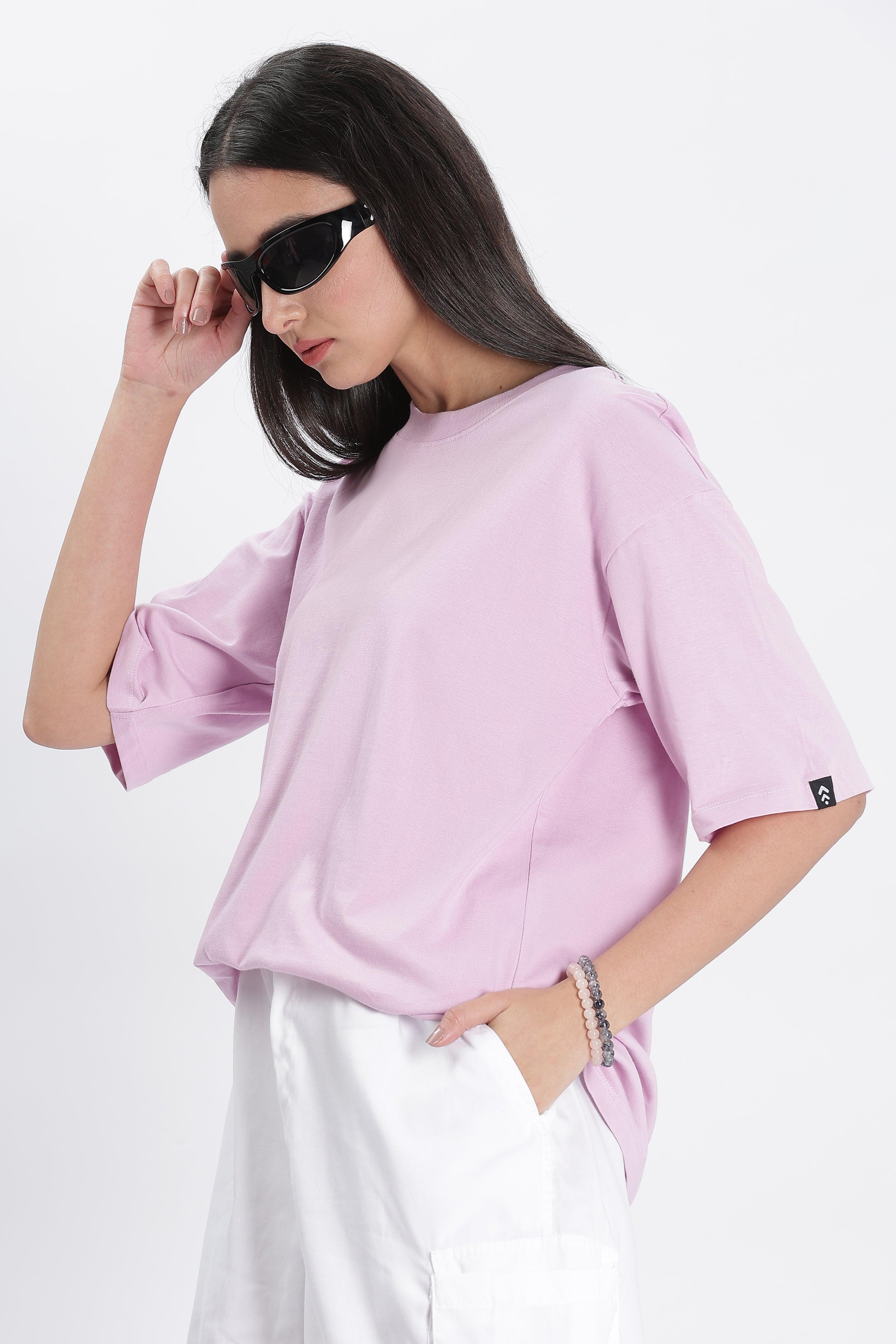 Woman wearing Soulmonk lavender oversized t-shirt with white pants and black sunglasses