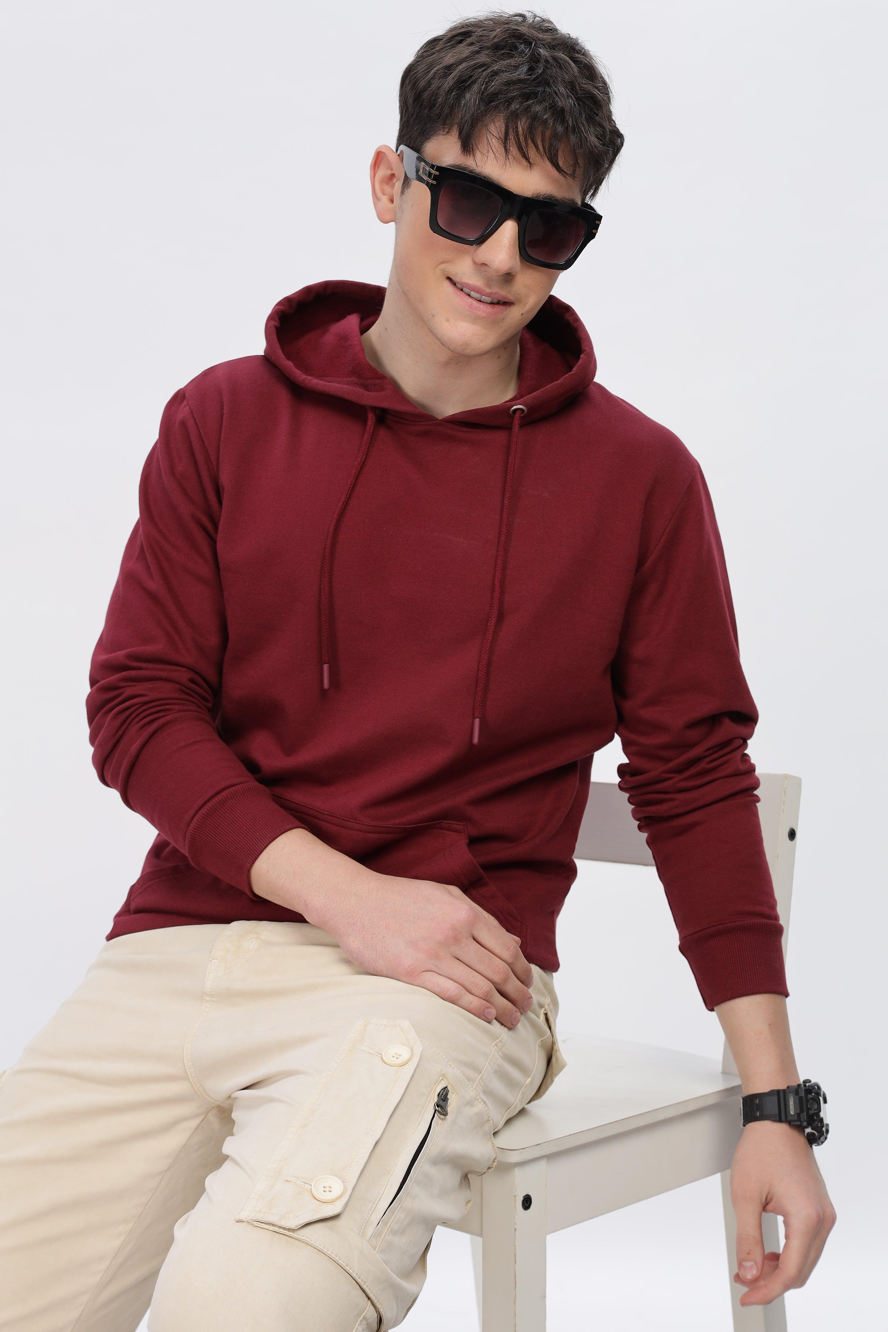 Male model wearing a maroon solid hoodie by Soulmonk with drawstrings and ribbed cuffs