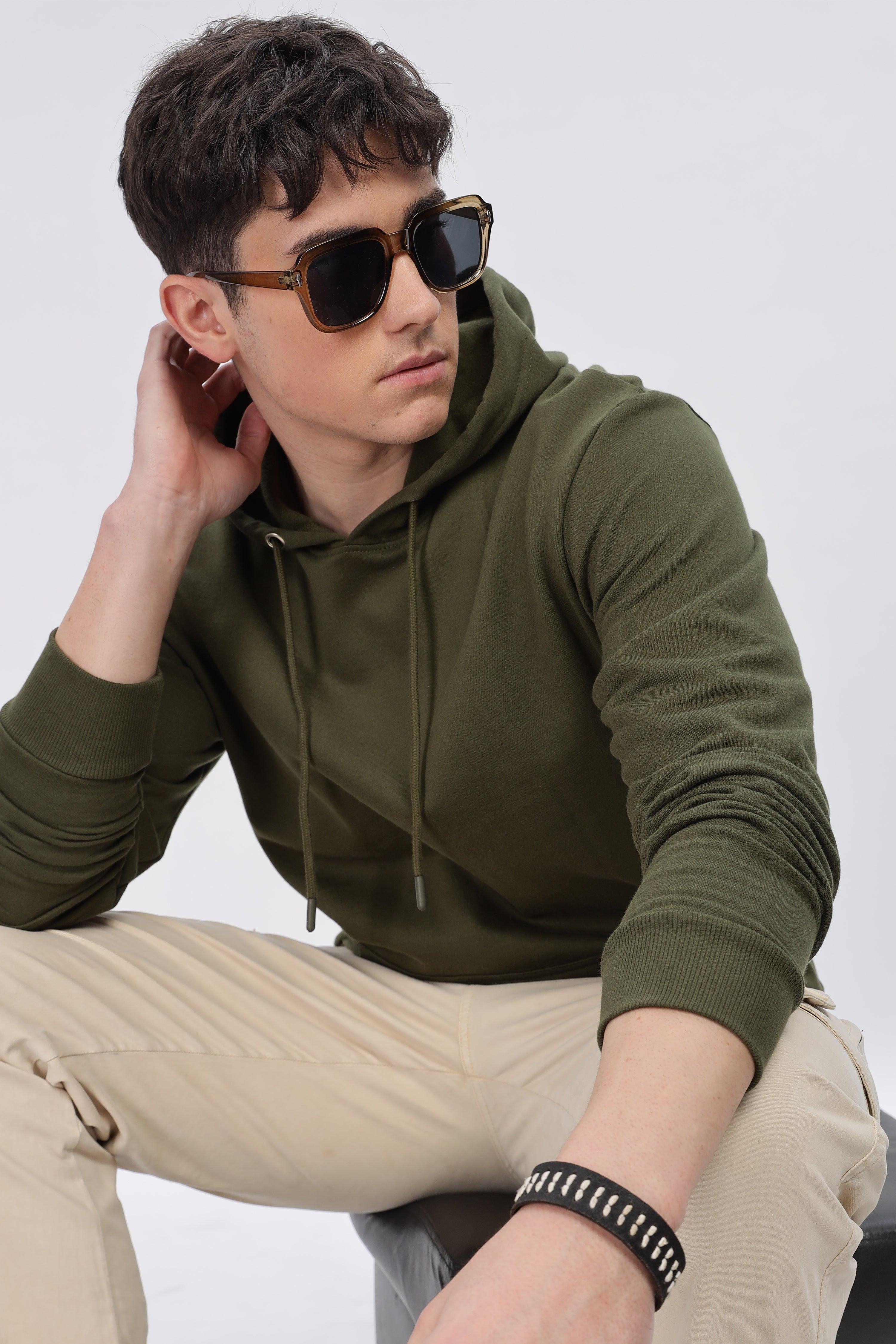 Male model wearing a Soulmonk olive green hoodie with drawstrings and beige pants
