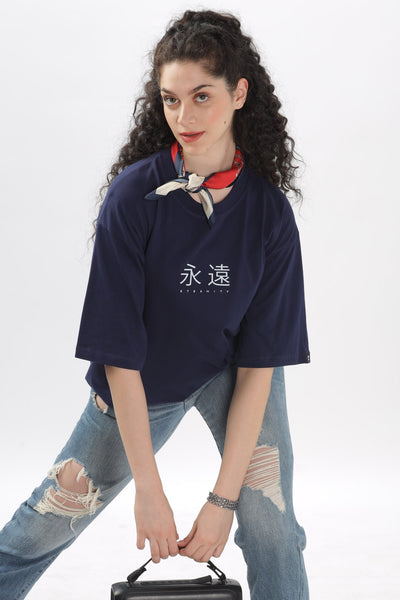 Soulmonk female model wearing a navy blue oversized t-shirt paired with ripped jeans and a red scarf