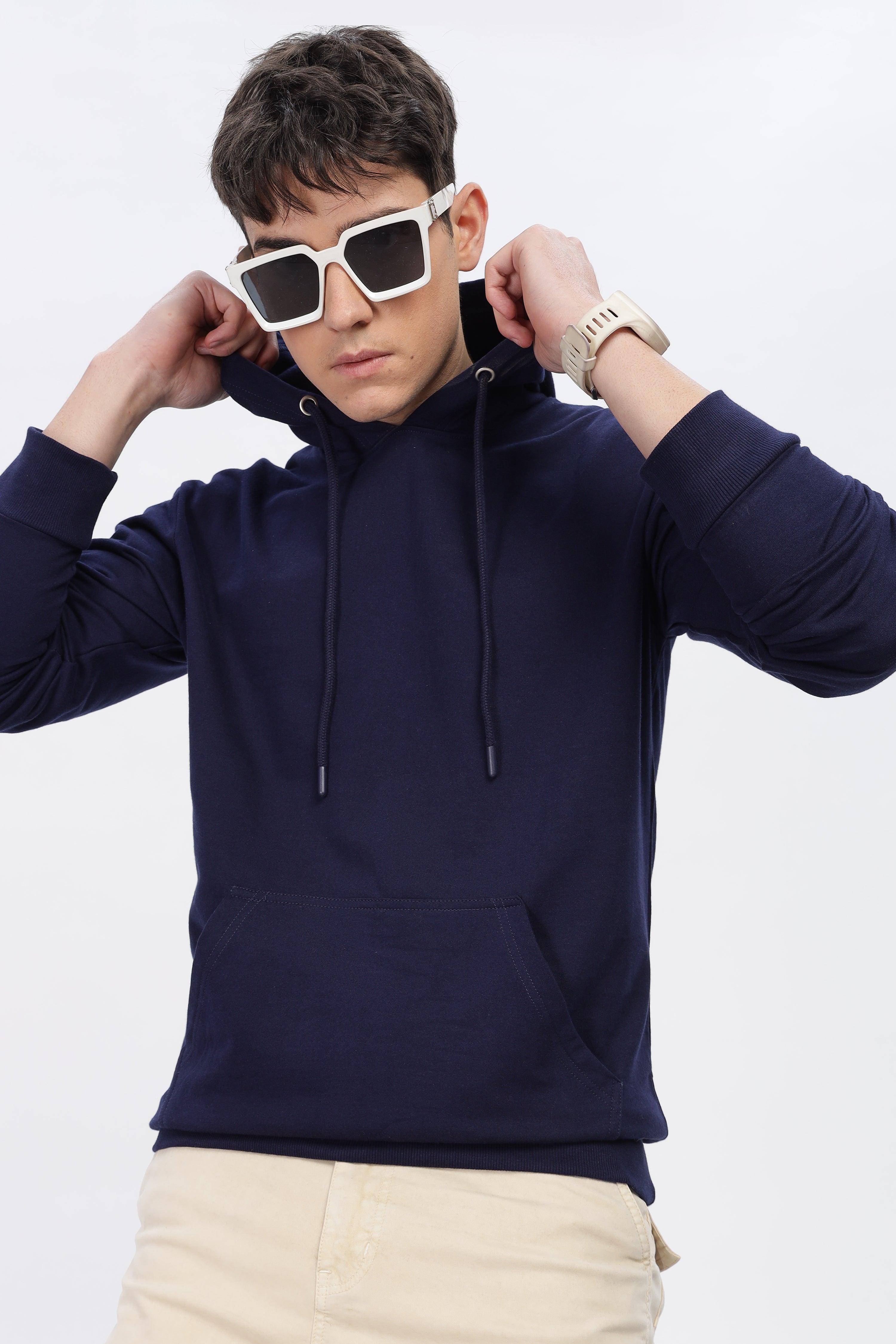 Male model wearing navy blue solid hoodie by Soulmonk with front pocket and adjustable hood strings