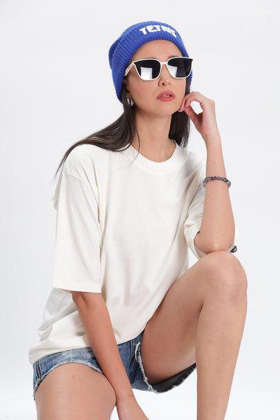 Soulmonk off white oversized t shirt worn by female model with blue beanie and sunglasses