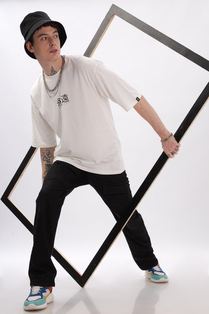 Male model wearing Soulmonk off-white oversized t-shirt with black pants and bucket hat