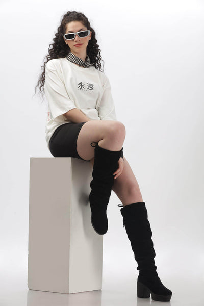 Soulmonk off-white oversized t-shirt worn by female model paired with black shorts and black knee-high boots