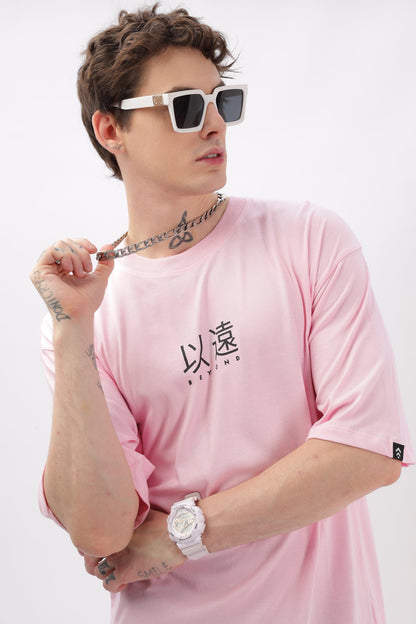 Male model wearing Soulmonk oversized soft pink t-shirt for men with black graphic print