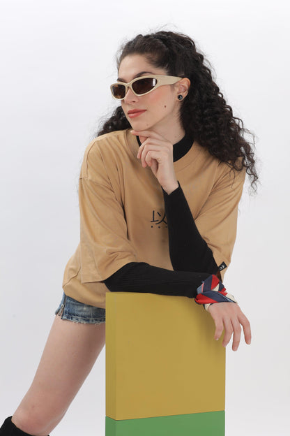 Female model wearing oversized taupe t-shirt by Soulmonk paired with black long sleeves and shorts