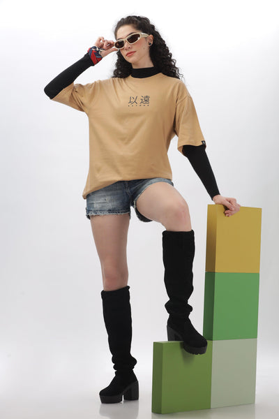 Soulmonk oversized taupe t-shirt worn by model with black long sleeves, denim shorts, and black knee-high boots