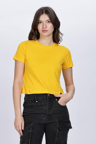 Female model wearing a soft yellow crop top paired with black cargo pants