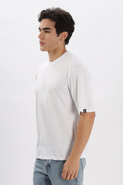 Male model wearing a white oversized t-shirt for men by Soulmonk paired with light blue jeans
